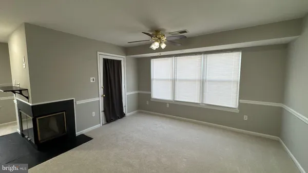 a view of an empty room with a fireplace and a window