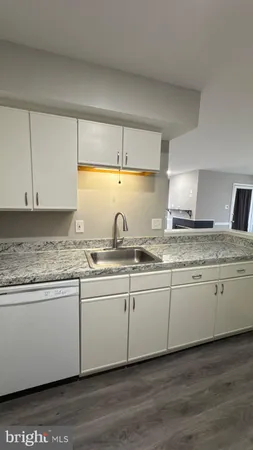 a kitchen with granite countertop cabinets sink and stove