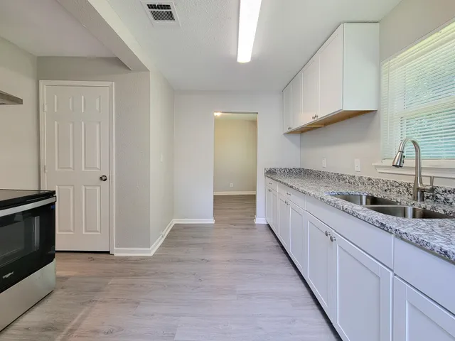 a kitchen with granite countertop a sink and a stove top oven