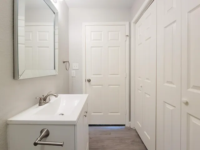 an empty room with a chandelier fan and windows