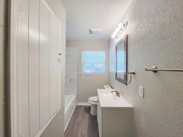 a bathroom with a sink a toilet and a tub