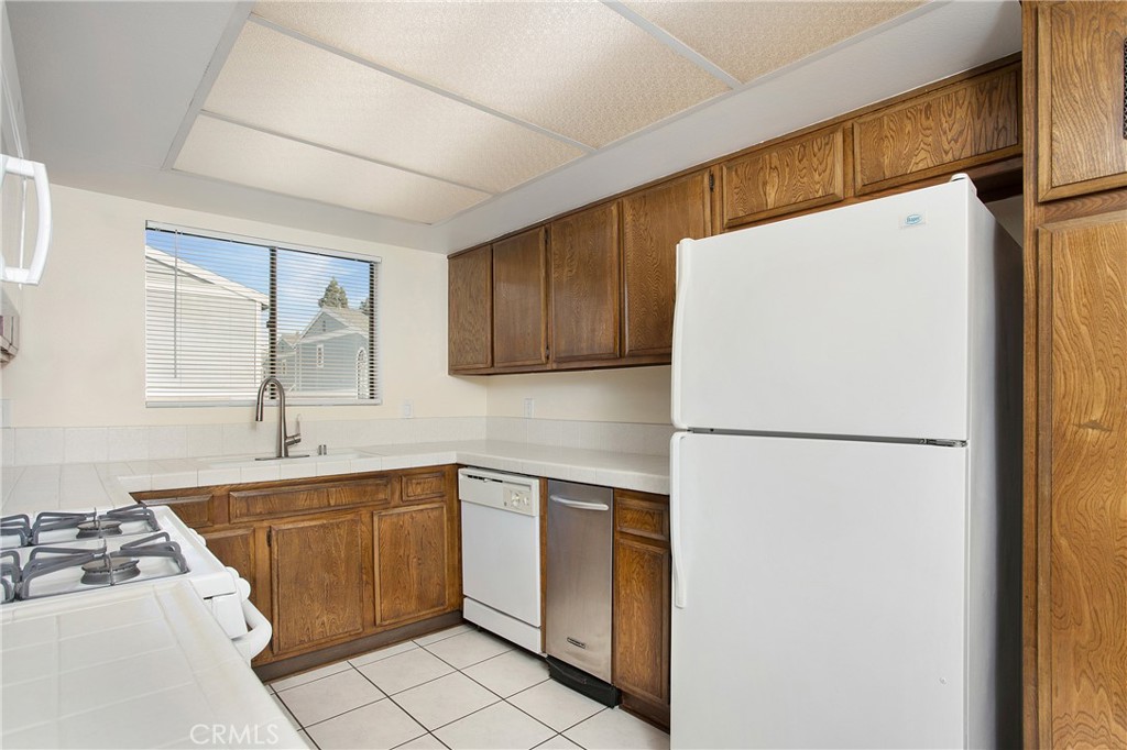 229 West Wilson Street, Unit 8 Costa Mesa, CA 92627 - Photo 6 of 11 a white refrigerator freezer sitting inside of a kitchen