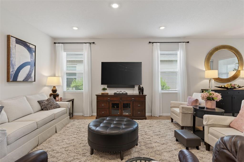 18237 Beach Ranch Terrace Bradenton, FL 34211 - Photo 29 of 72 a living room with furniture a flat screen tv and a large window