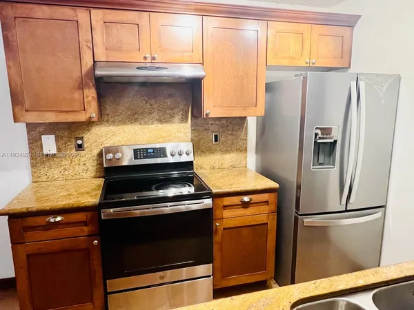 a kitchen with a refrigerator stove and sink