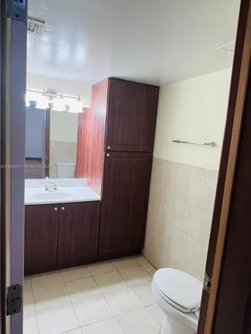a bathroom with a sink a toilet a mirror and vanity