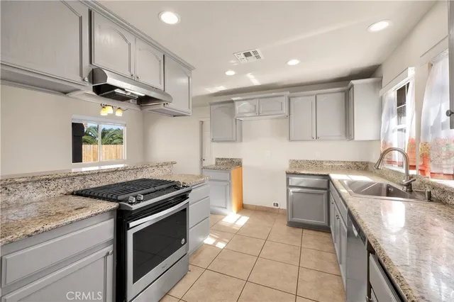 a kitchen with a sink stove top oven and cabinets