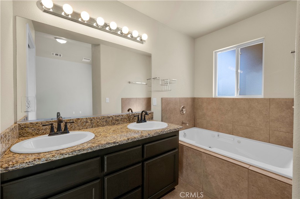 57031 Selecta Avenue Yucca Valley, CA 92284 - Photo 20 of 56 a bathroom with a granite countertop sink a mirror and a bathtub