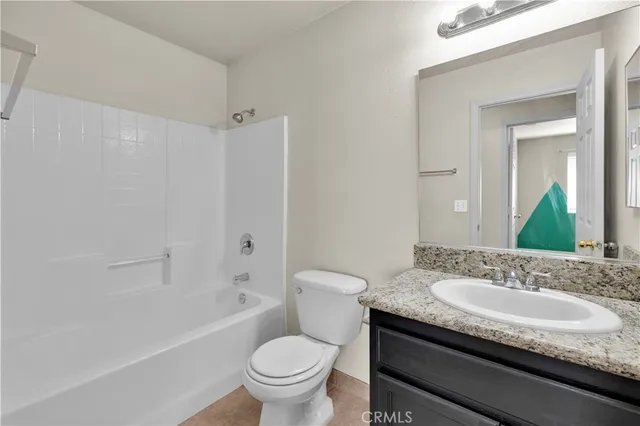 a bathroom with a granite countertop sink a mirror and a shower