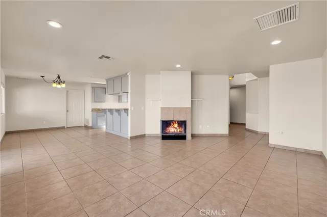 an empty room with fireplace and windows