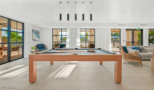 a living room with furniture fireplace and large windows