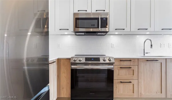 a kitchen with stainless steel appliances granite countertop a stove microwave and refrigerator