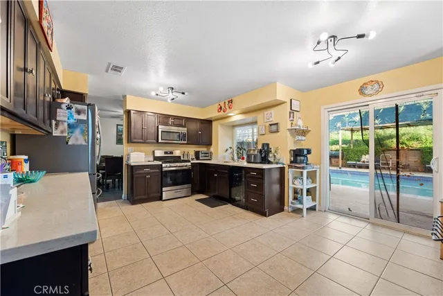 a kitchen with stainless steel appliances kitchen island granite countertop a refrigerator and a stove top oven