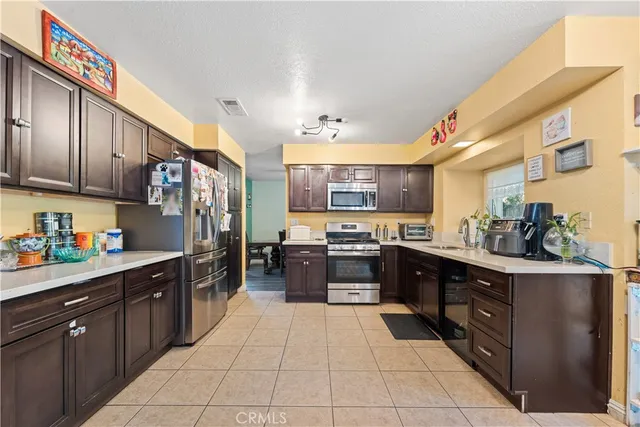 a kitchen with stainless steel appliances granite countertop a stove a sink dishwasher and a refrigerator