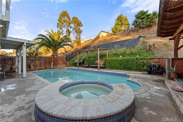 a view of a swimming pool with lawn chairs under an umbrella
