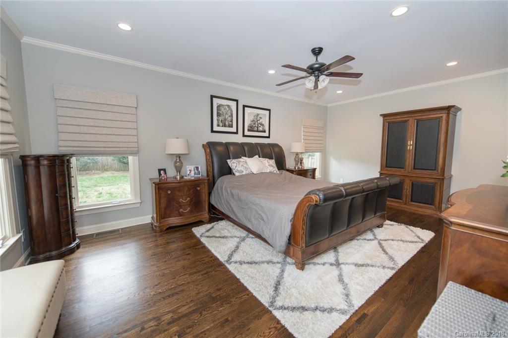 2837 Sharon Road Charlotte, NC 28211 - Photo 17 of 24 a bedroom with a bed and a chandelier