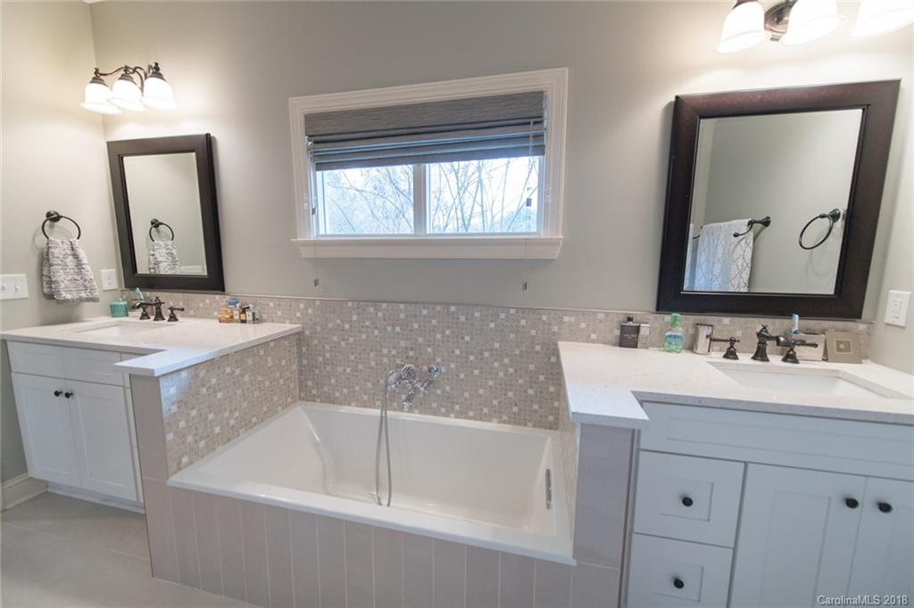 2837 Sharon Road Charlotte, NC 28211 - Photo 20 of 24 a bathroom with a bathtub a double vanity sink and mirror