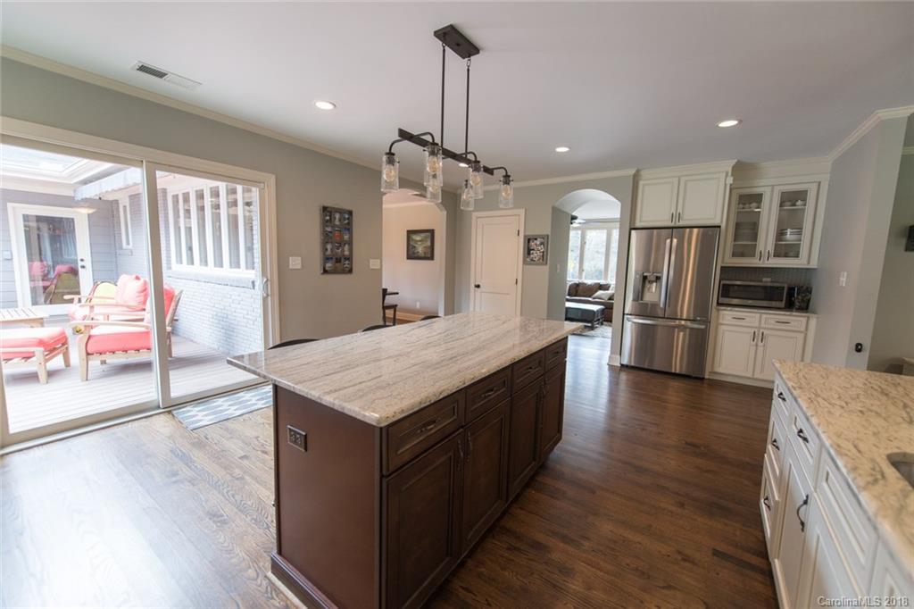 2837 Sharon Road Charlotte, NC 28211 - Photo 5 of 24 a kitchen with stainless steel appliances kitchen island granite countertop a refrigerator a stove and a sink with wooden floor