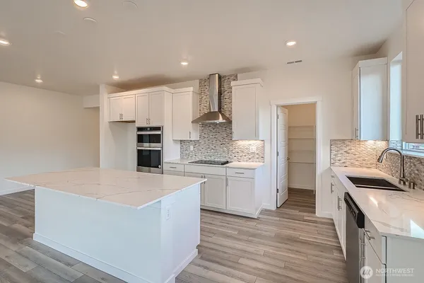 a view of an empty room with wooden floor and a painting