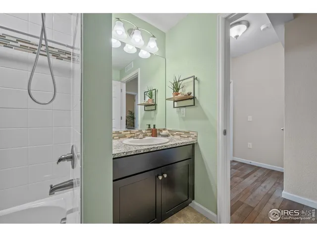 a bathroom with a granite countertop sink a mirror and shower