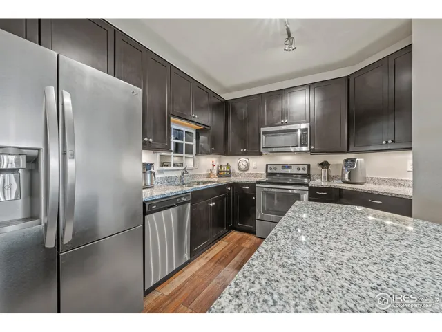 a kitchen with kitchen island stainless steel appliances cabinets a sink and a counter