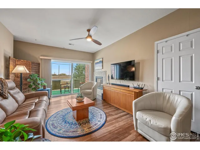 a living room with furniture a flat screen tv and a large window