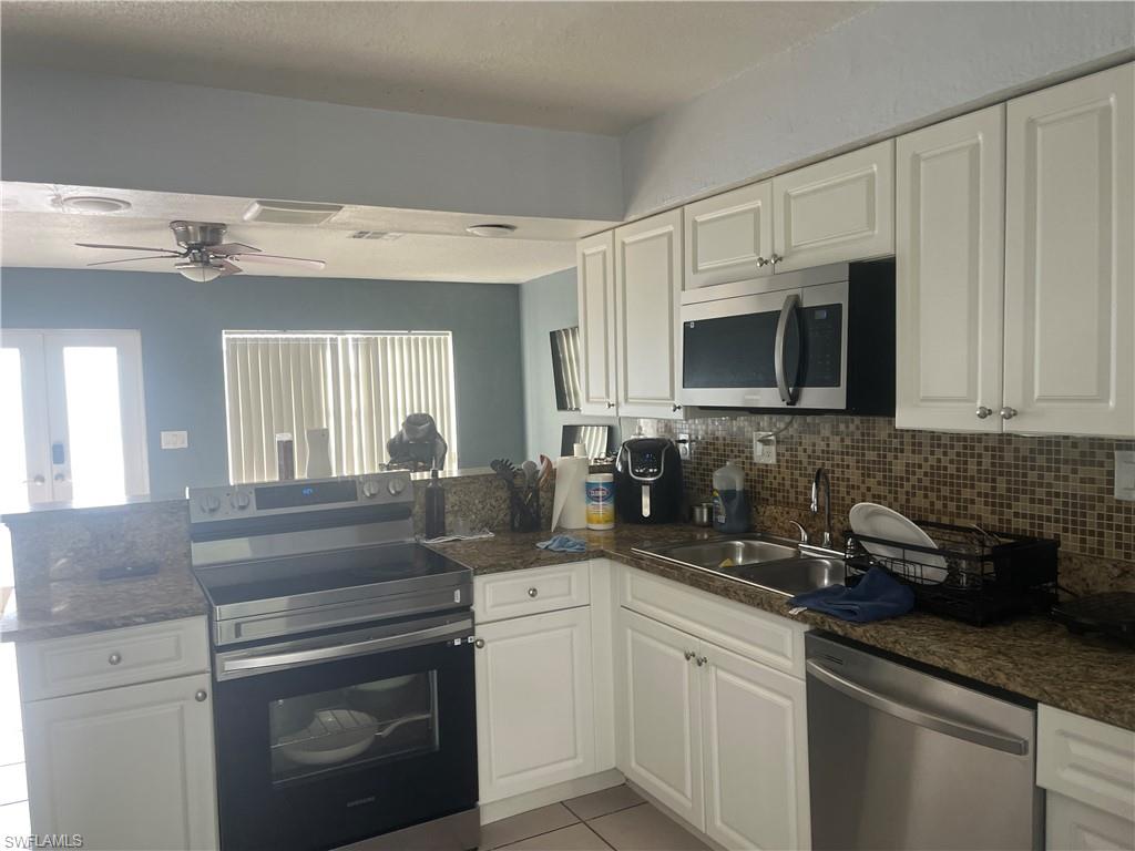 101 East Jersey Road Lehigh Acres, FL 33936 - Photo 4 of 10 a kitchen with appliances a sink and cabinets
