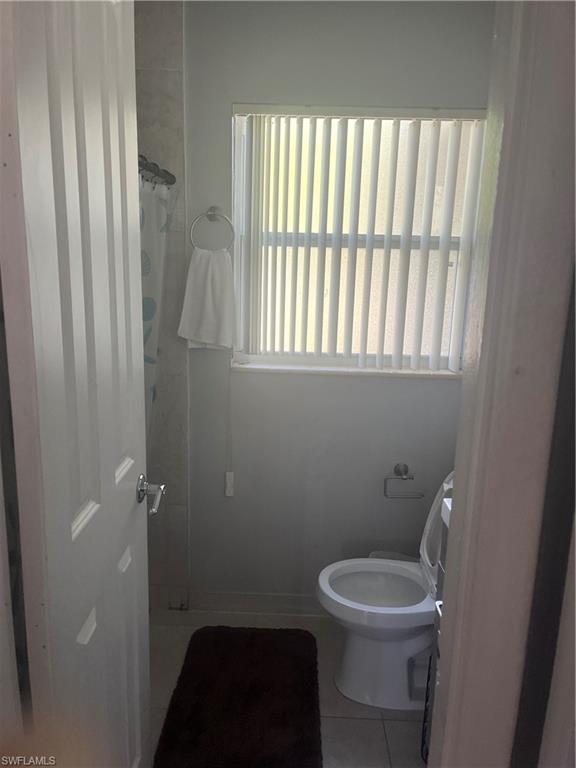 101 East Jersey Road Lehigh Acres, FL 33936 - Photo 6 of 10 a bathroom with a toilet a sink and a window