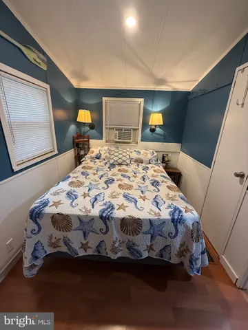 a bedroom with a bed and a dresser with rug