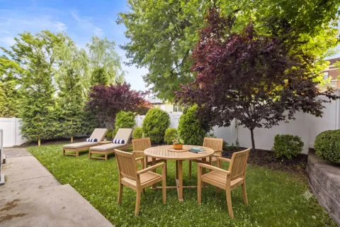 a view of a chairs and table in backyard