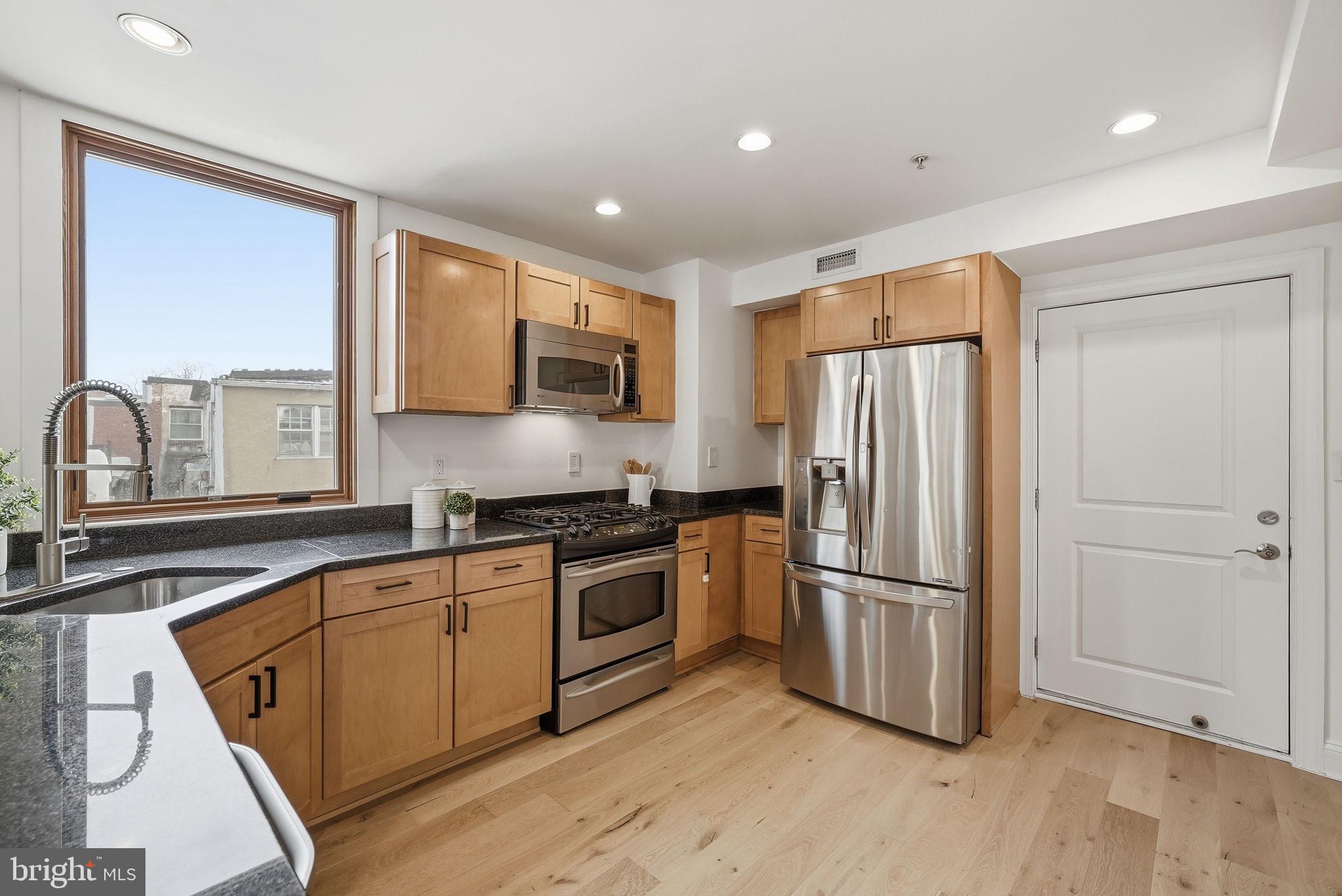 2713 Ontario Road Northwest, Unit 5 Washington, DC 20009 - Photo 5 of 35 a kitchen with stainless steel appliances granite countertop a refrigerator and a stove top oven