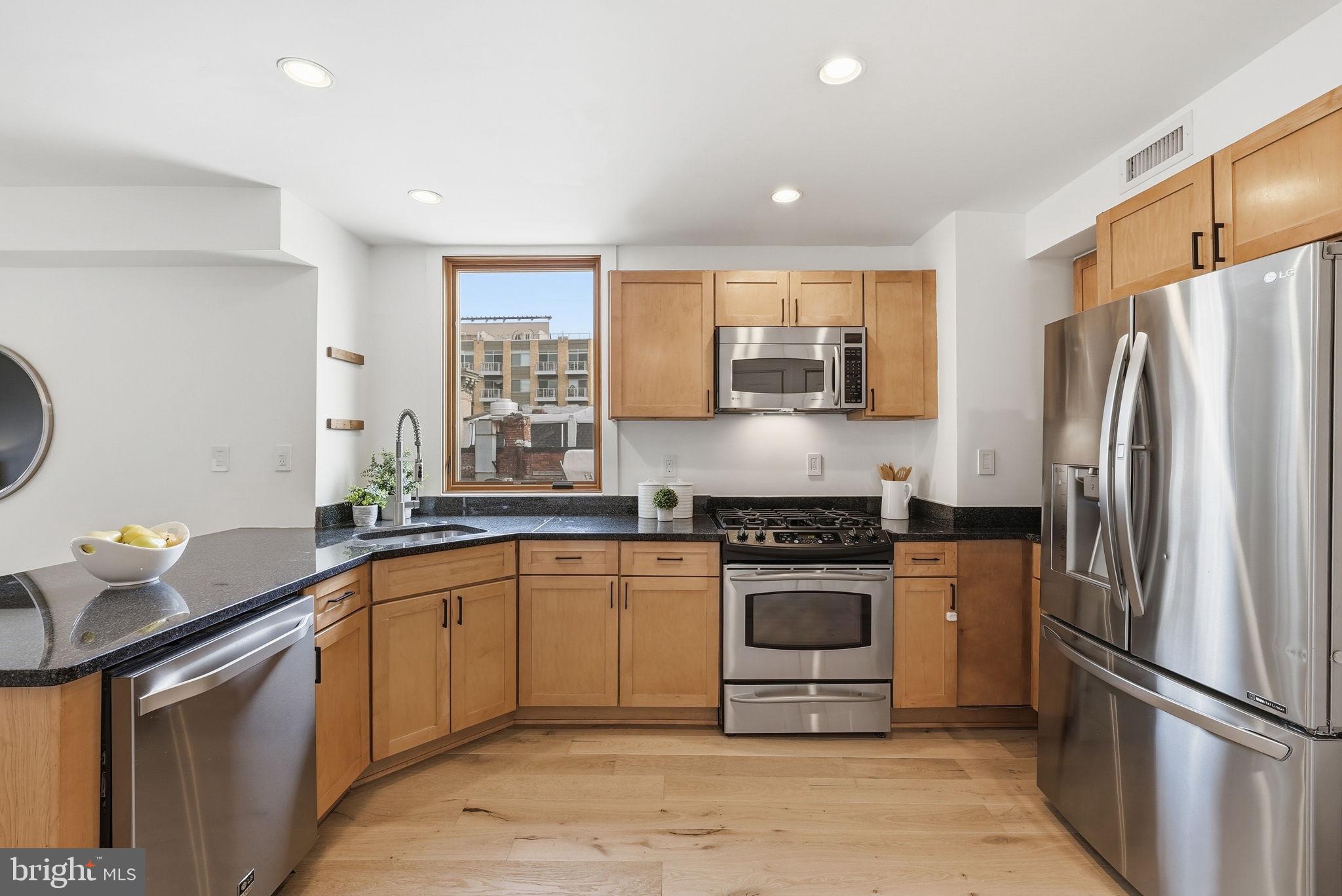 2713 Ontario Road Northwest, Unit 5 Washington, DC 20009 - Photo 6 of 35 a kitchen with stainless steel appliances granite countertop a sink stove and refrigerator
