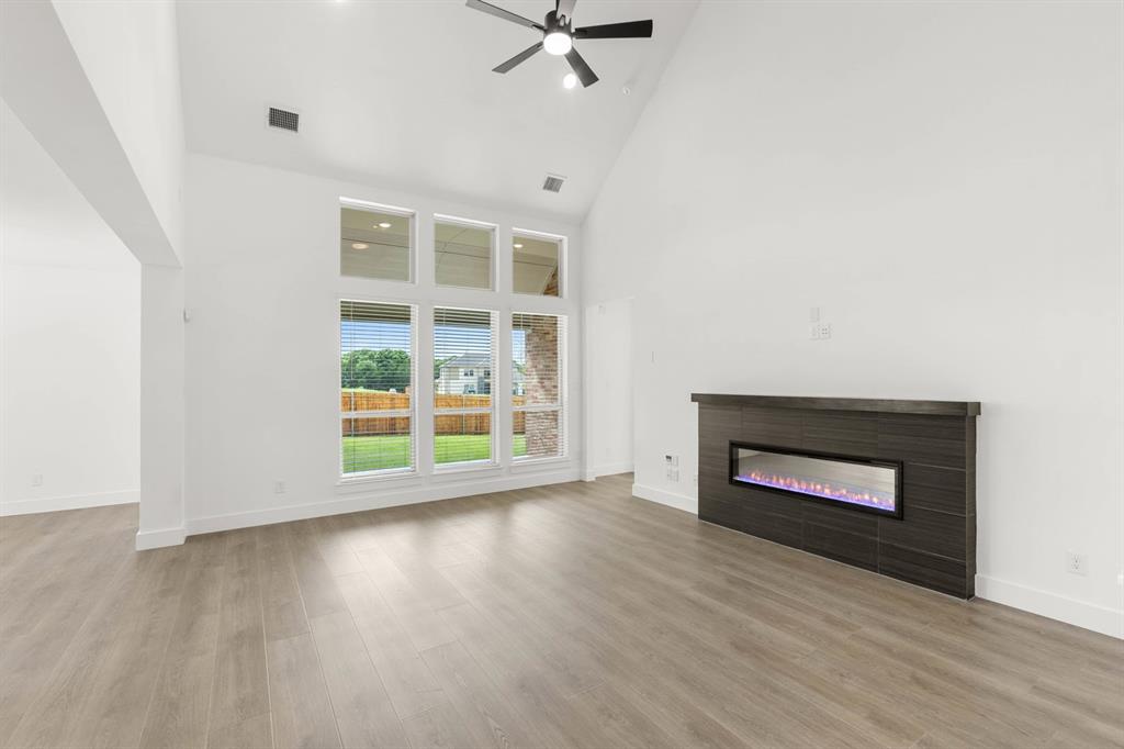 413 Tower Street DeSoto, TX 75115 - Photo 4 of 30 an empty room with wooden floor fireplace and windows
