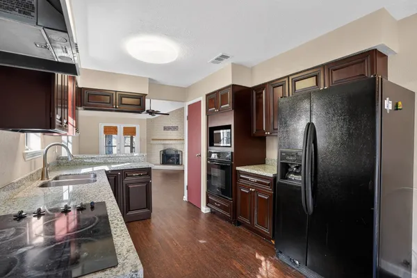 a kitchen with stainless steel appliances granite countertop a refrigerator a stove and a sink