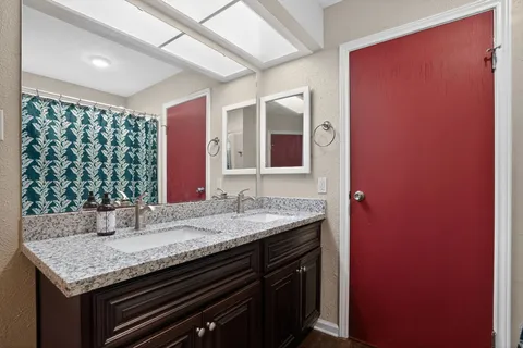 a bathroom with a granite countertop sink toilet and shower