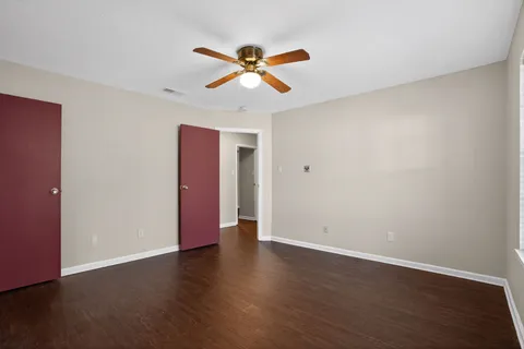 a view of a room with wooden floor and ceiling fan