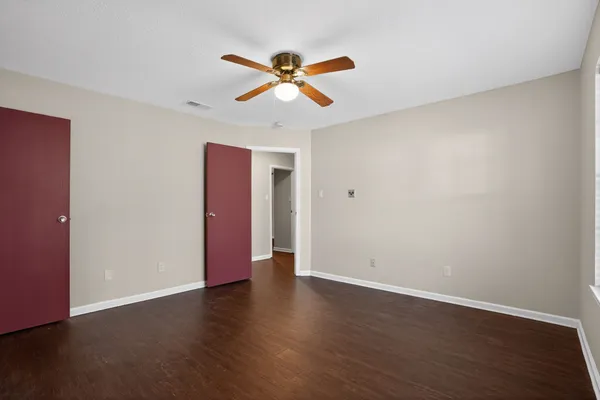 a view of a room with wooden floor and ceiling fan