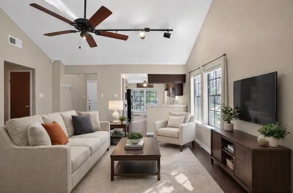 an empty room with wooden floor and windows