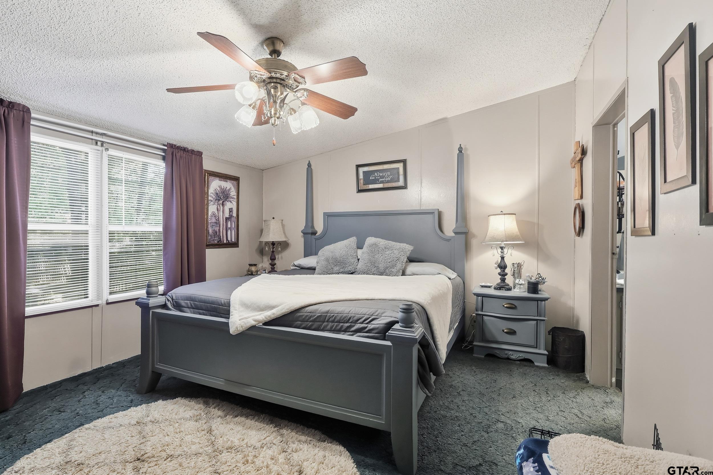 264 County Road 2169 Quitman, TX 75783 - Photo 31 of 34 a spacious bedroom with a bed and a chandelier