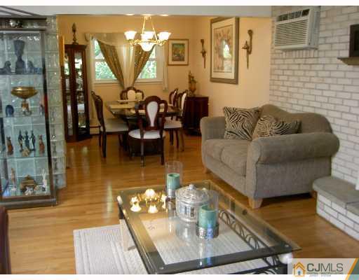 4 Kings Road East Brunswick, NJ 08816 - Photo 3 of 9 a living room with couches and a dining table with wooden floor