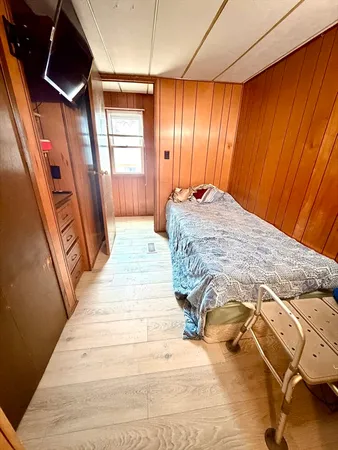 a bedroom with a bed and wooden floor
