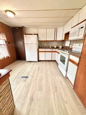 a kitchen with a refrigerator and white cabinets