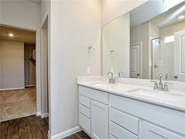a bathroom with a granite countertop sink a mirror a vanity and a shower
