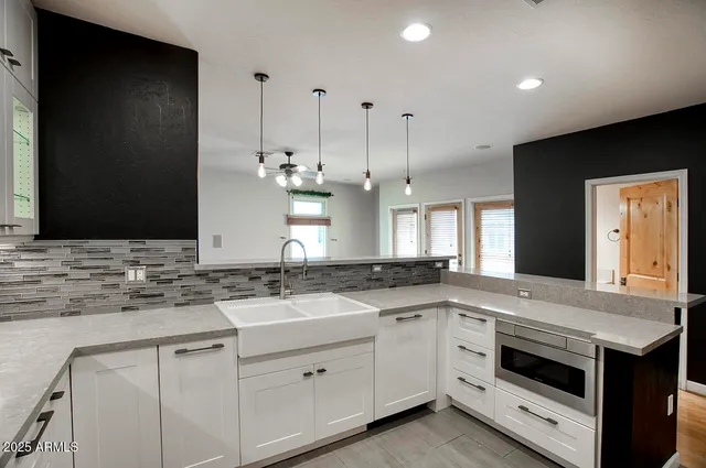 a kitchen with granite countertop stainless steel appliances sink and cabinets