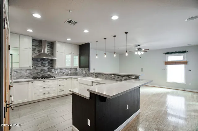 a kitchen with a stove a sink a refrigerator and white cabinets