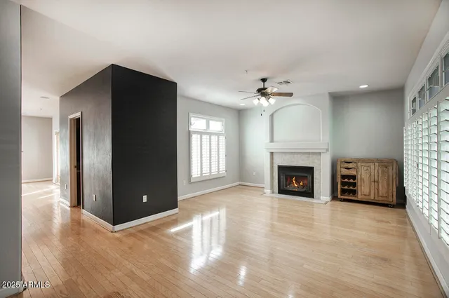 an empty room with fireplace and windows