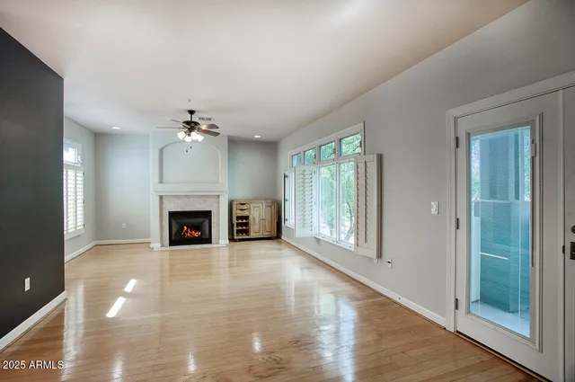 a view of an empty room with window and fire place