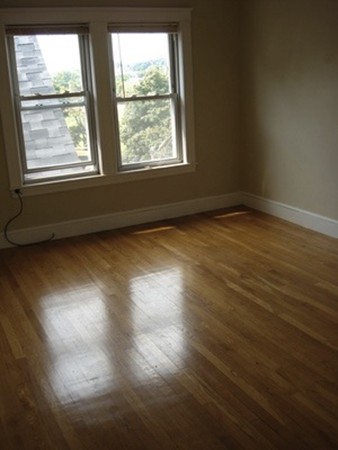 12 Playstead Road, Unit 3 Boston, MA 02125 - Photo 5 of 6 an empty room with wooden floor and windows