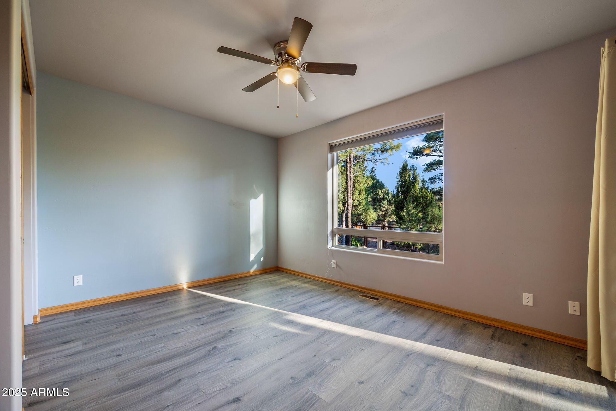 3429 Ponderosa Loop Heber, AZ 85928 - Photo 36 of 75 an empty room with wooden floor chandelier fan and windows