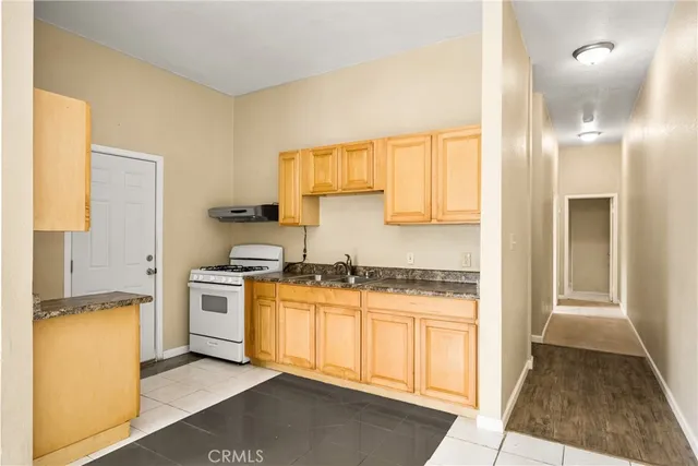 a kitchen with stainless steel appliances granite countertop a stove a sink and a refrigerator
