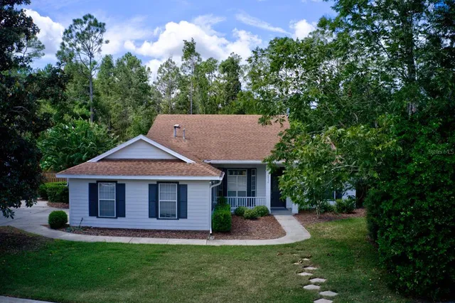 a front view of a house with a yard and trees